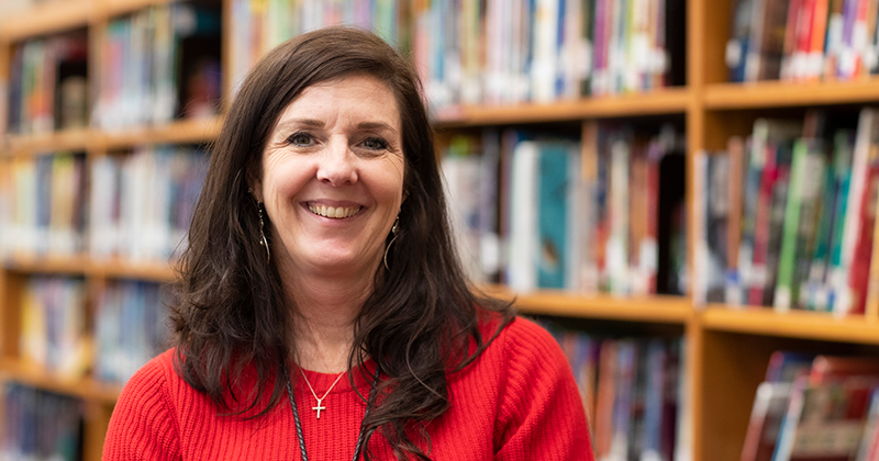 special education teacher in front of library books