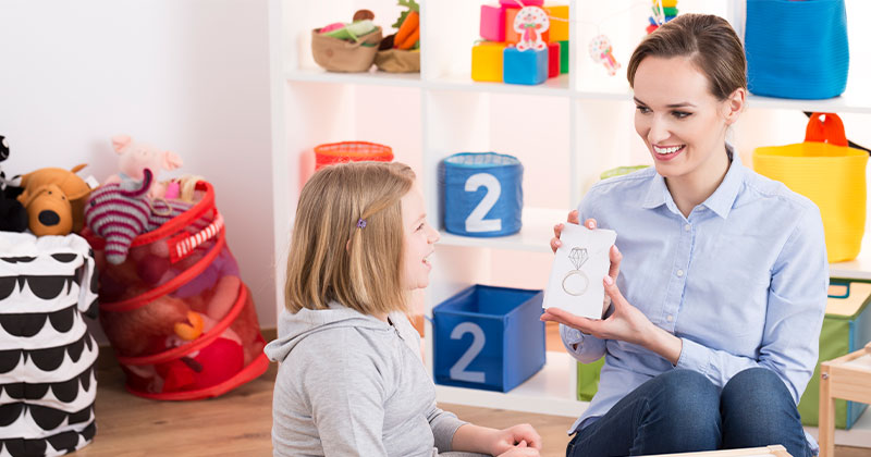 teacher showing flash card to student