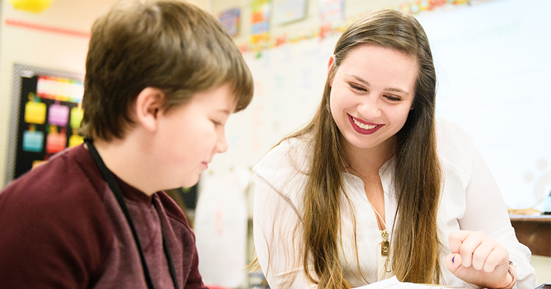 student at desk with teacher