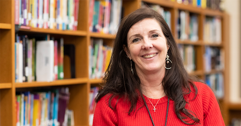 teacher in front of library books