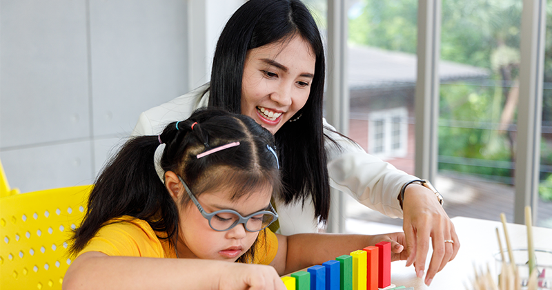 special education teacher working with child at table