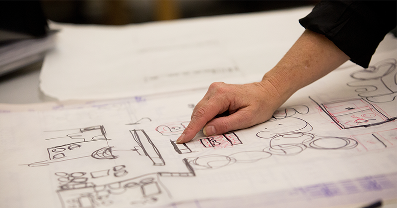 hand pointing to chart on table