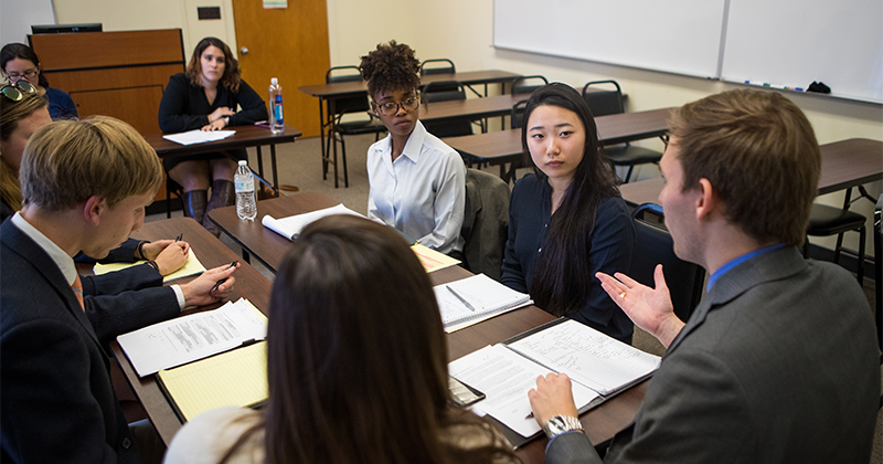 students around table with professor